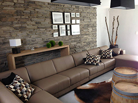 Salon, divan et mur en pierres